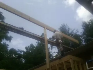 Carpenter setting a ridge beam over a new addition frame — Ice Dam Removal by Roofing Brothers in Doon