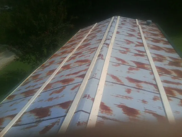Rusted metal roof panels with new wood purlins before replacement — Storm Damage Roof Repair in Doon by Roofing Brothers
