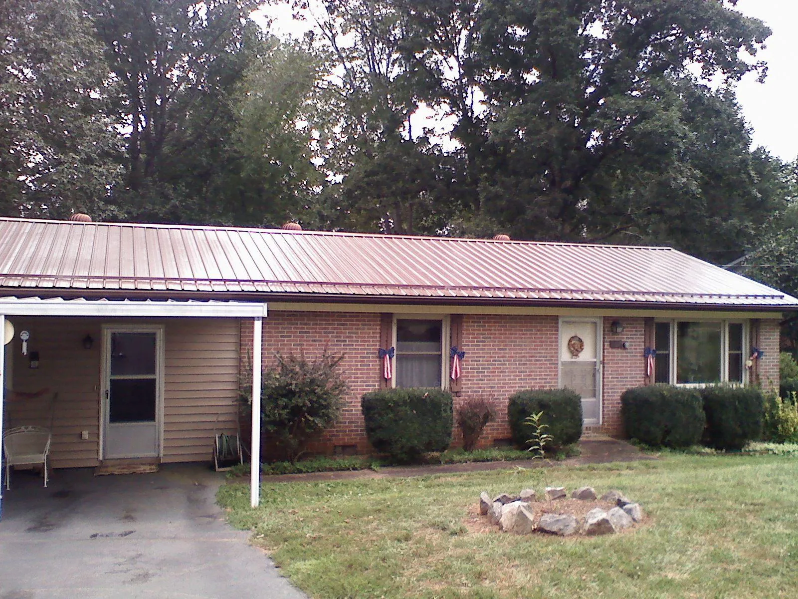 Bronze metal roof and carport on a brick ranch home — Roof Repair work by our crew in Doon